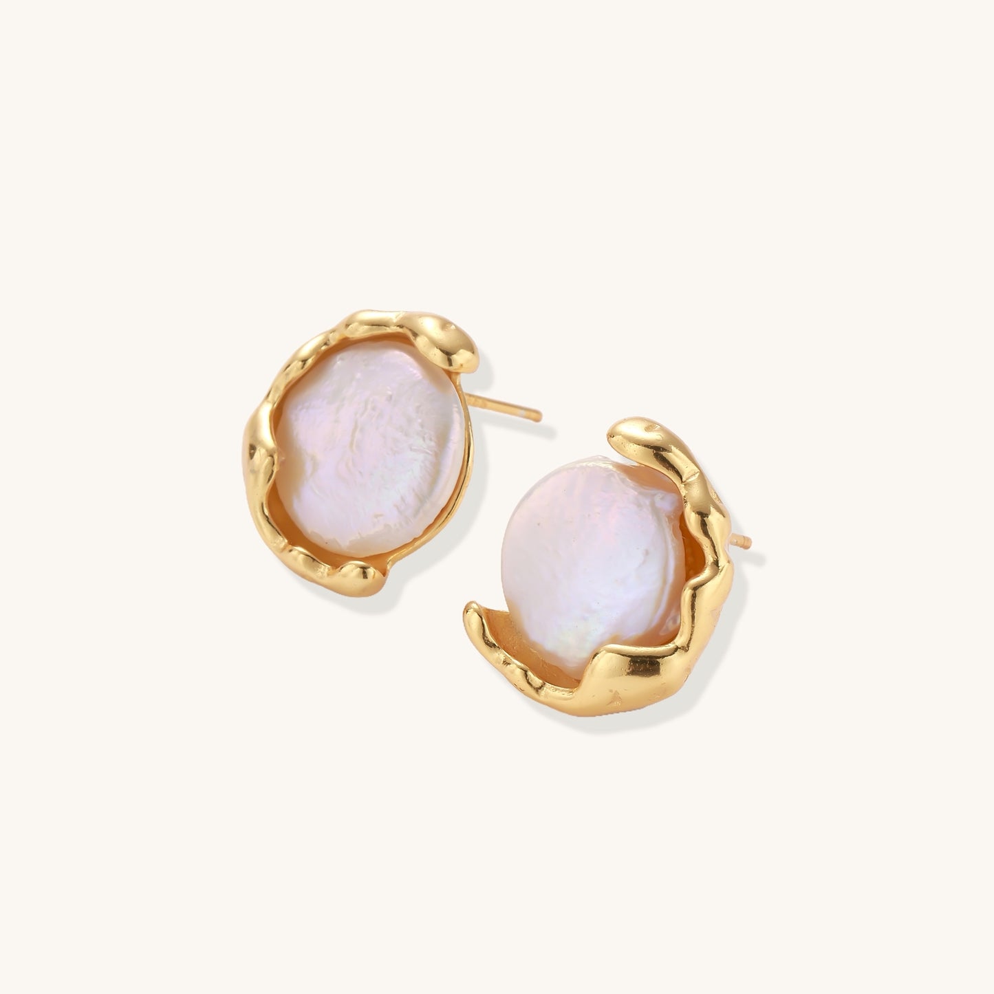Gold-plated sterling silver stud earrings with organic claw settings cradling lustrous freshwater pearls on white background.