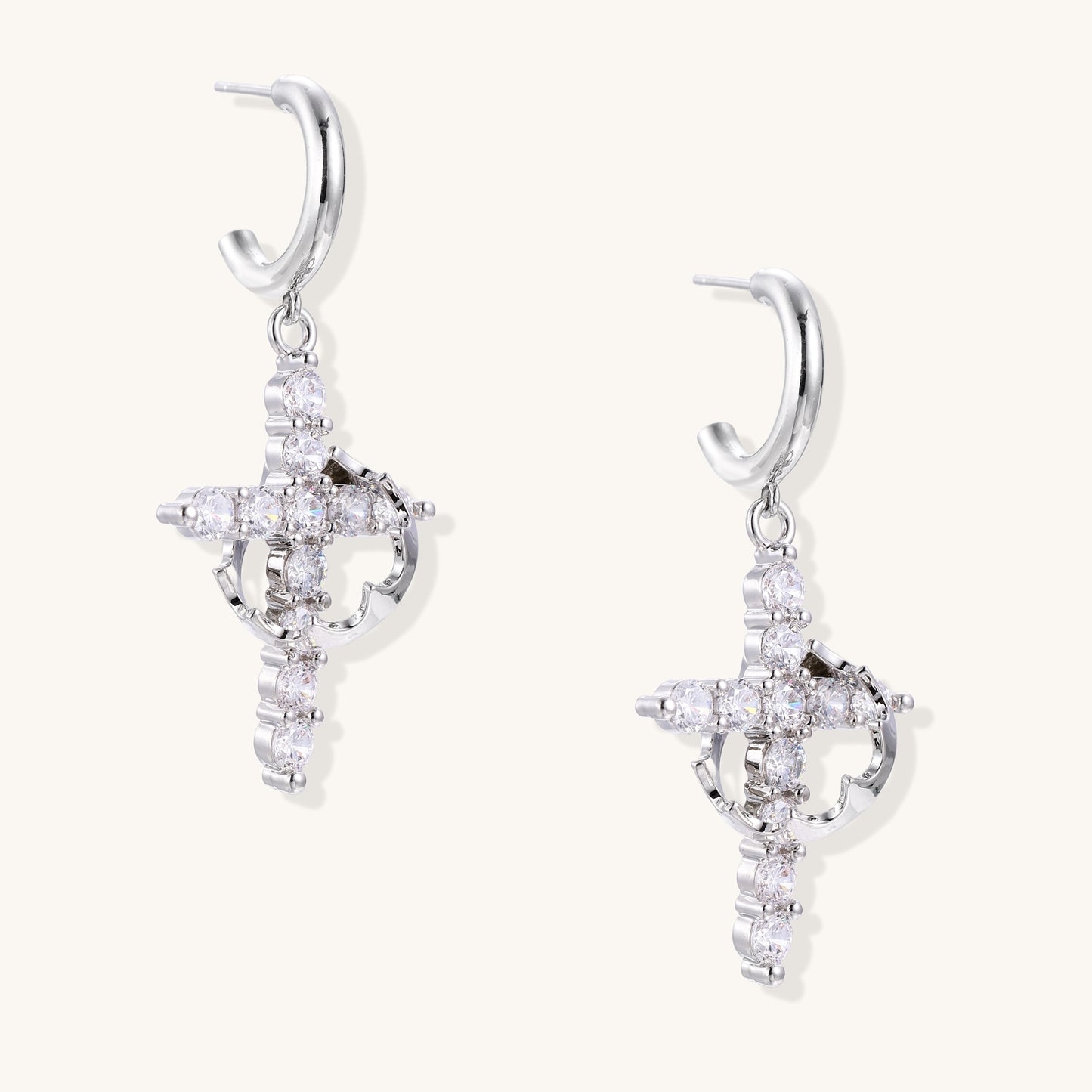 Ornate cross dangle earrings with zirconia stones and gold-plated brass construction on white background.