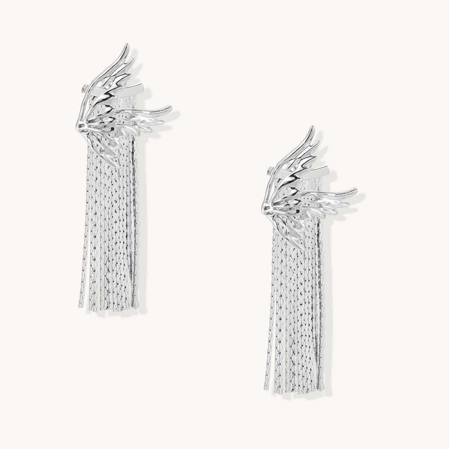 Gold-plated wing earrings with delicate chain fringe tassels creating movement and celestial appeal