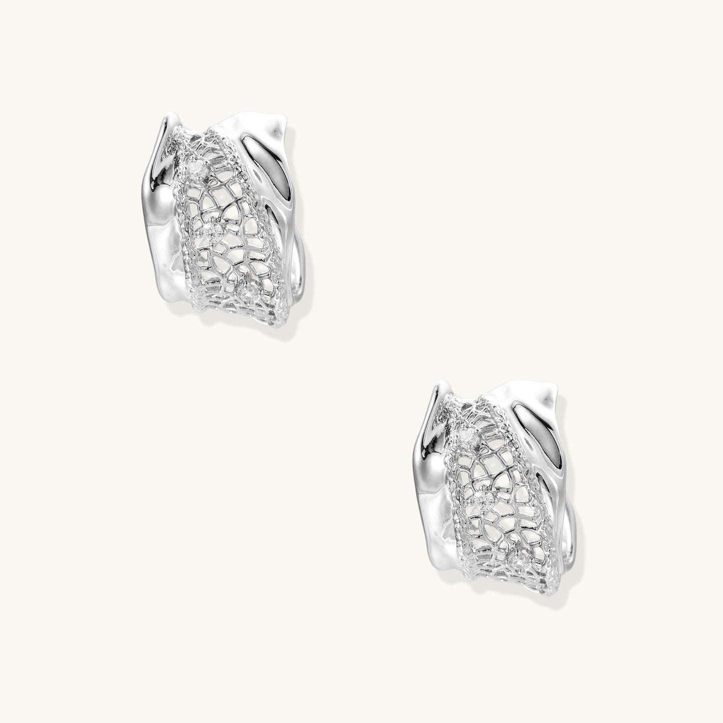 Small gold-plated brass hoop earrings with geometric lattice pattern and zirconia accents on white background.