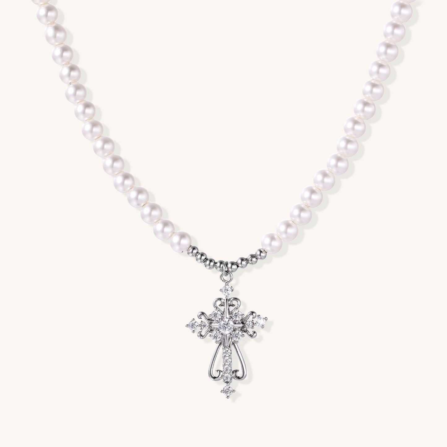 Elegant pearl necklace with ornate 18K gold plated cross pendant featuring zirconia stones on neutral background.