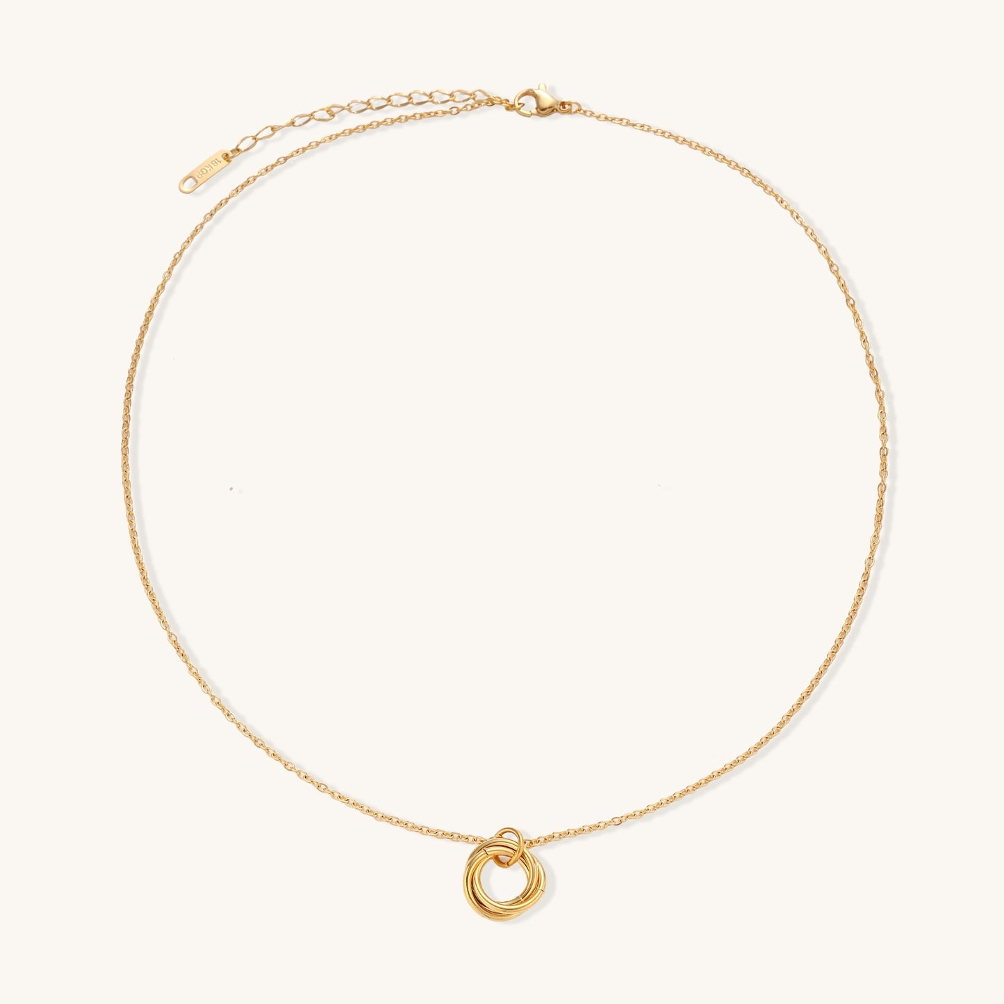Close-up of a gold-plated stainless steel necklace with interlocking twisted ring pendant on white background