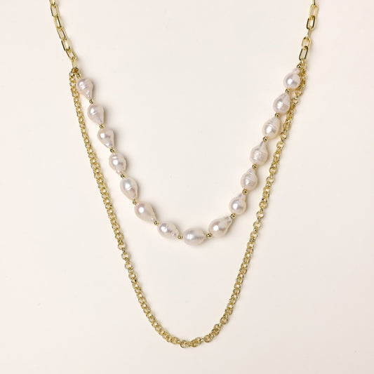 Layered gold chain necklace with irregular freshwater pearls on cream background, showing adjustable dual-strand design.