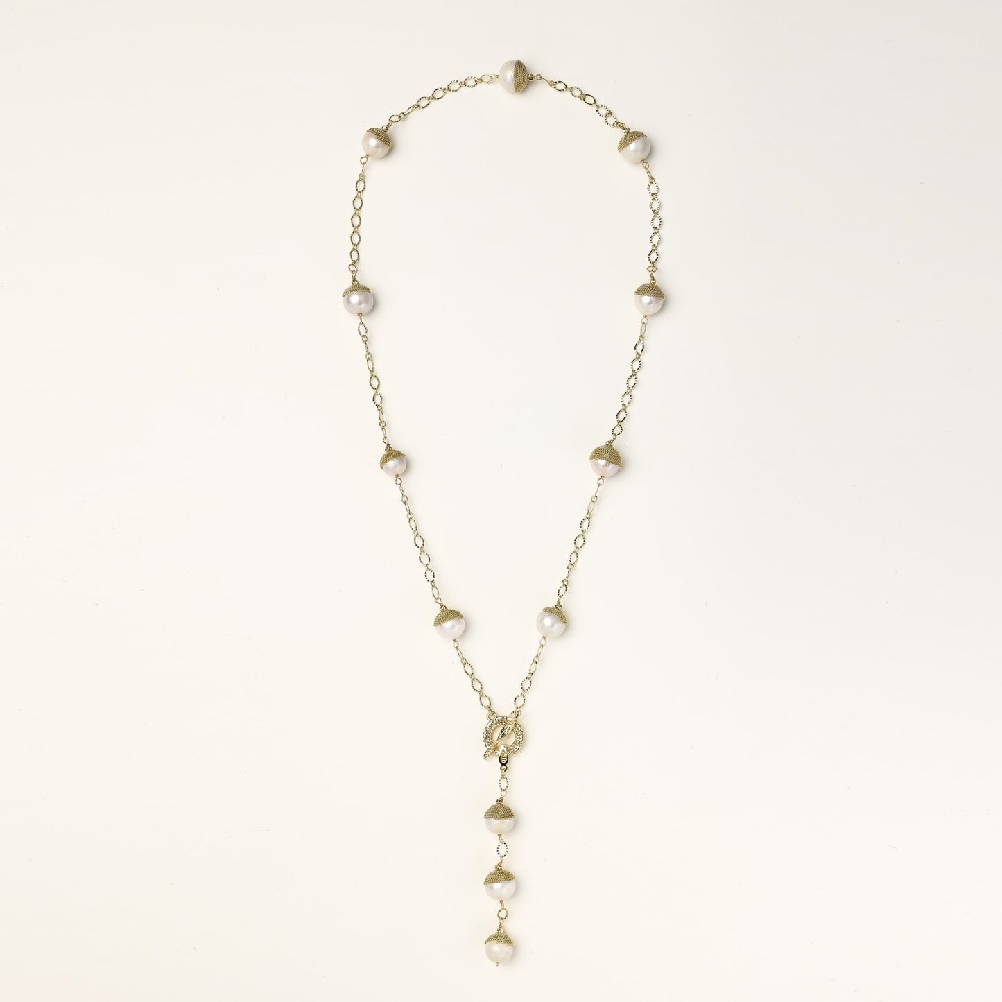 Long gold-plated lariat necklace featuring baroque pearls with metal caps arranged in elegant Y-shape design