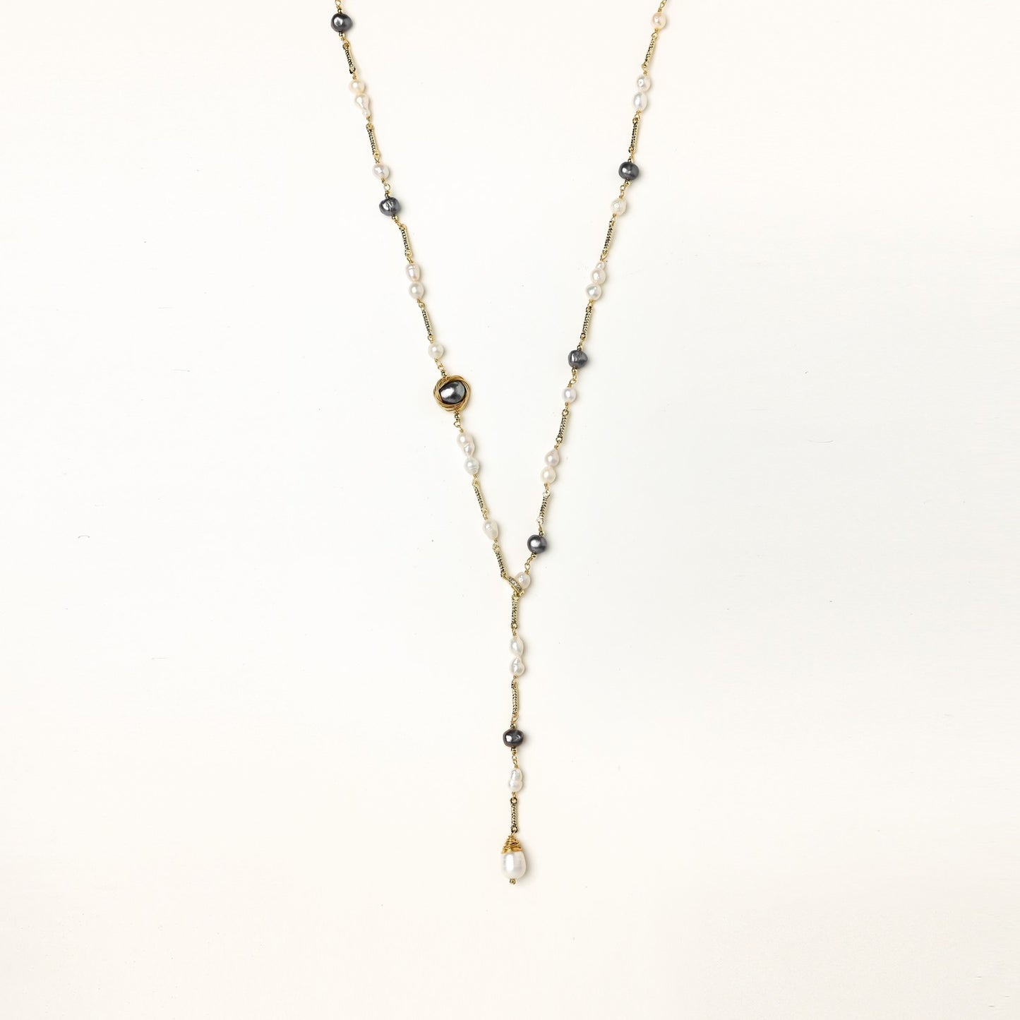Long gold-plated necklace with alternating white and gray freshwater pearls spaced along delicate chain segments