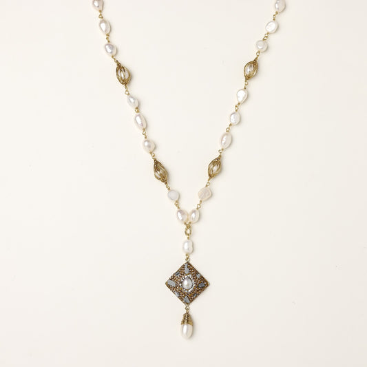 Elegant 14K gold plated necklace with freshwater pearls and ornate crystal diamond pendant on cream background.