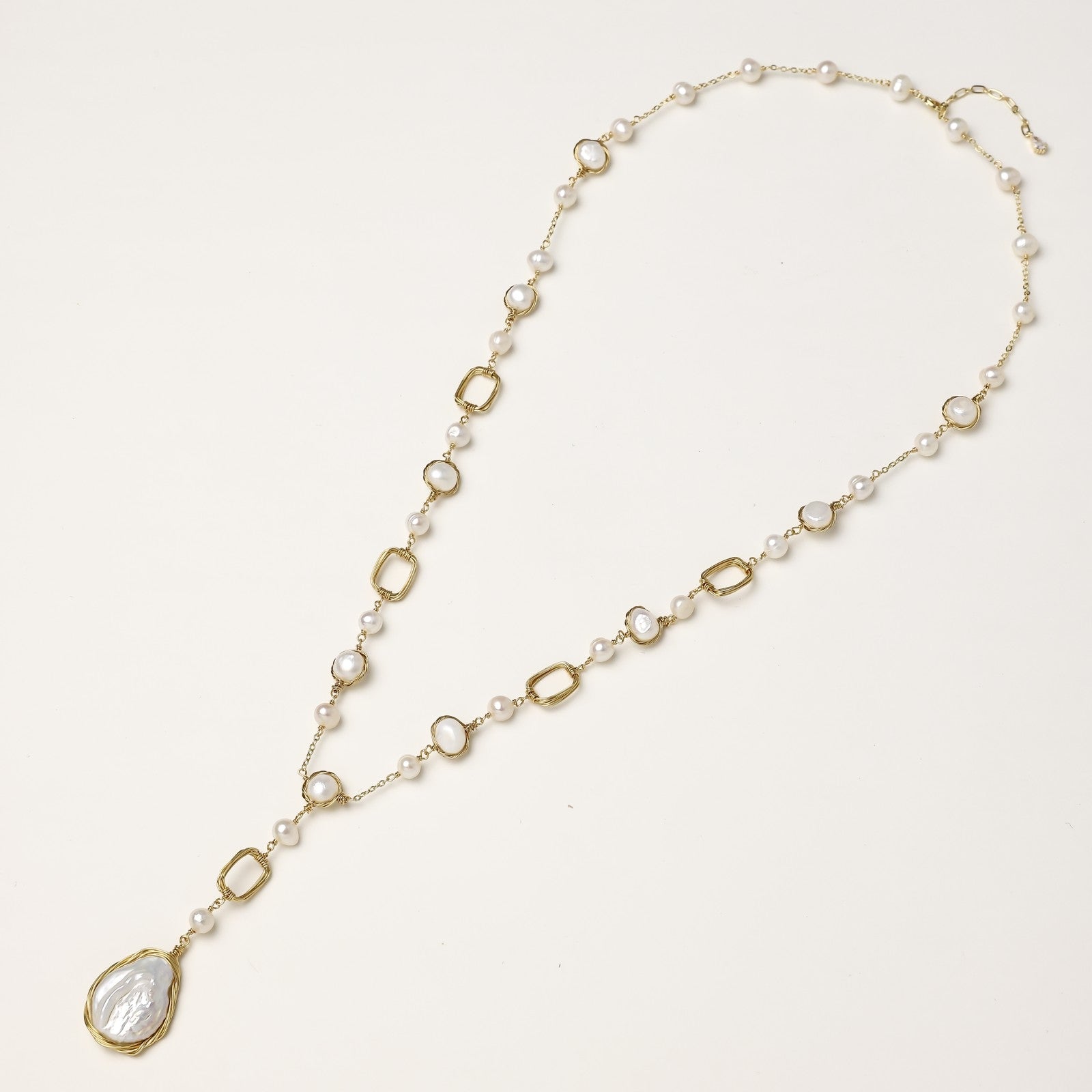 Y-shaped gold-plated necklace with freshwater pearls and geometric elements, featuring a baroque pearl pendant drop