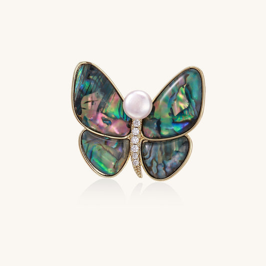 Iridescent abalone shell butterfly pin with central pearl and gold setting, showing rainbow color reflections