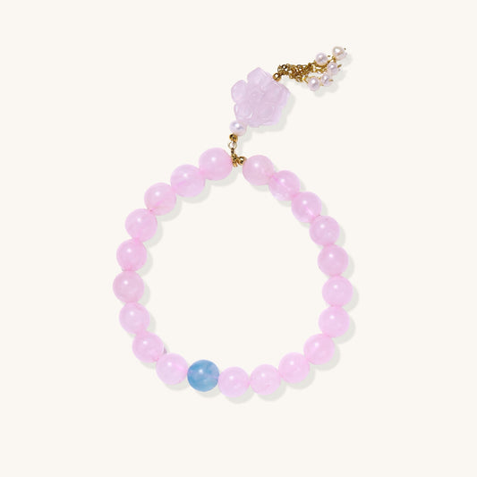 Beaded bracelet with pink rose quartz stones, blue aquamarine accent, and pearl chain details on white background