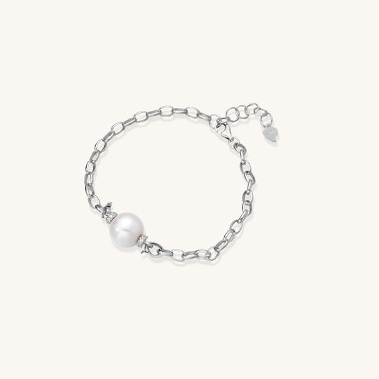 Dainty sterling silver chain bracelet with round freshwater pearl and crystal accents on white background.