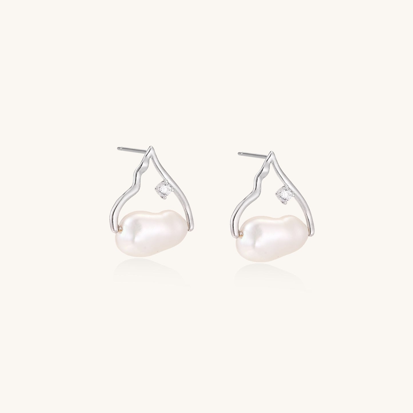 Sterling silver teardrop-shaped stud earrings with white freshwater pearls nestled in elegant flame-like frames