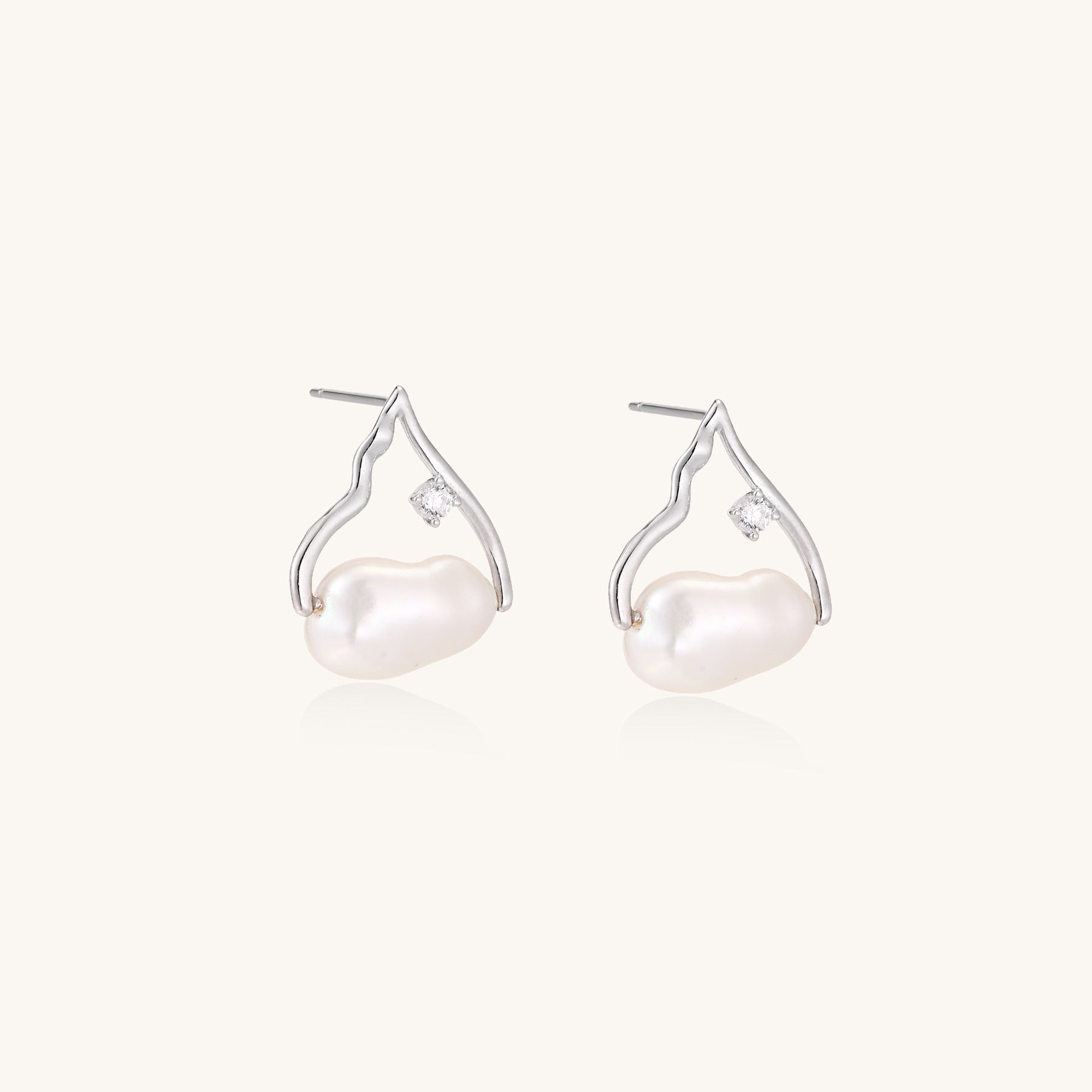 Sterling silver teardrop-shaped stud earrings with white freshwater pearls nestled in elegant flame-like frames