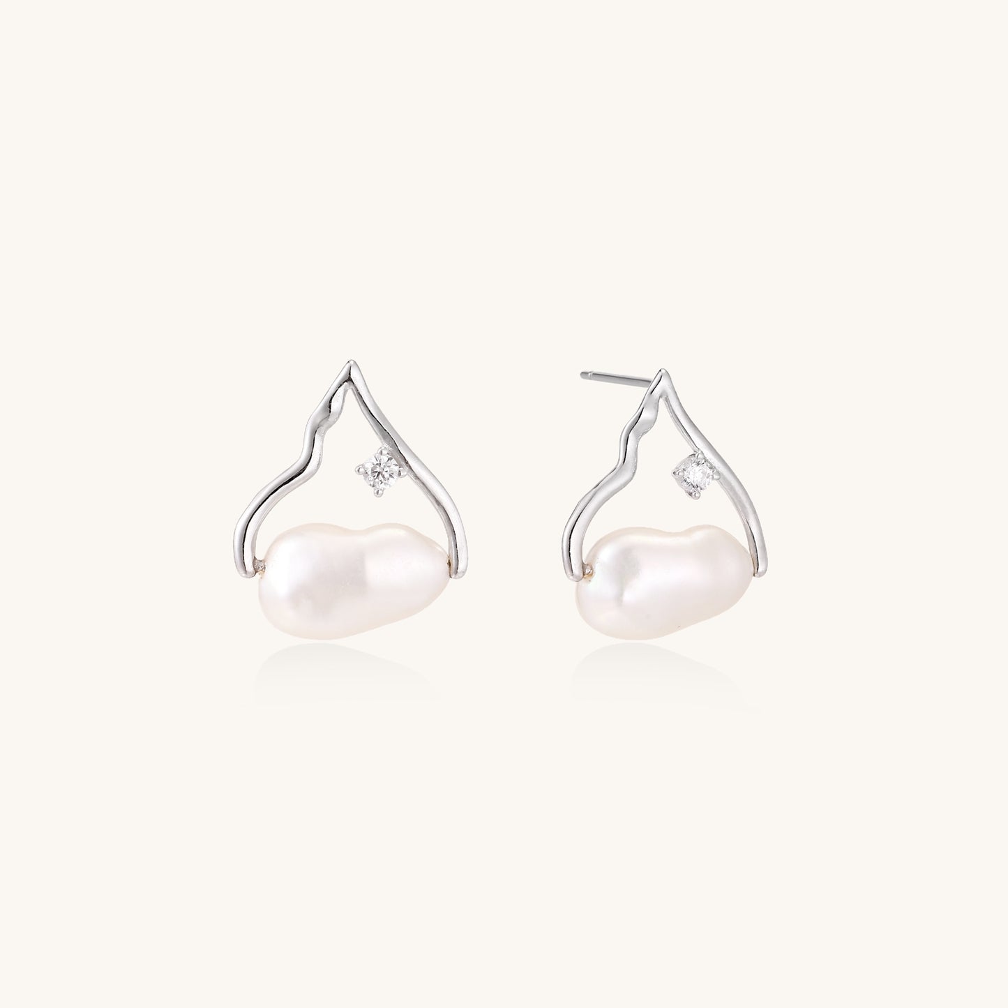 Sterling silver teardrop-shaped stud earrings with white freshwater pearls nestled in elegant flame-like frames