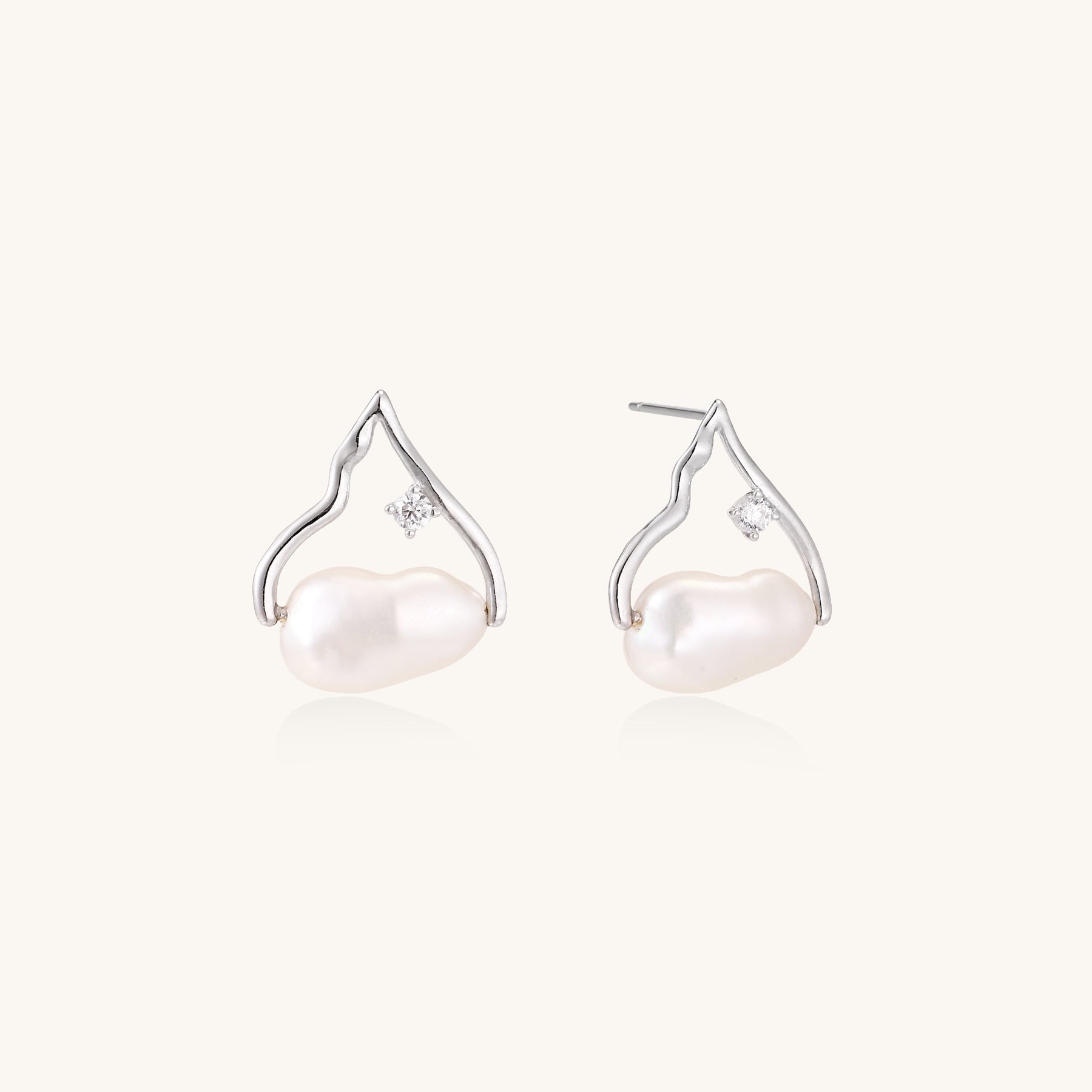 Sterling silver teardrop-shaped stud earrings with white freshwater pearls nestled in elegant flame-like frames