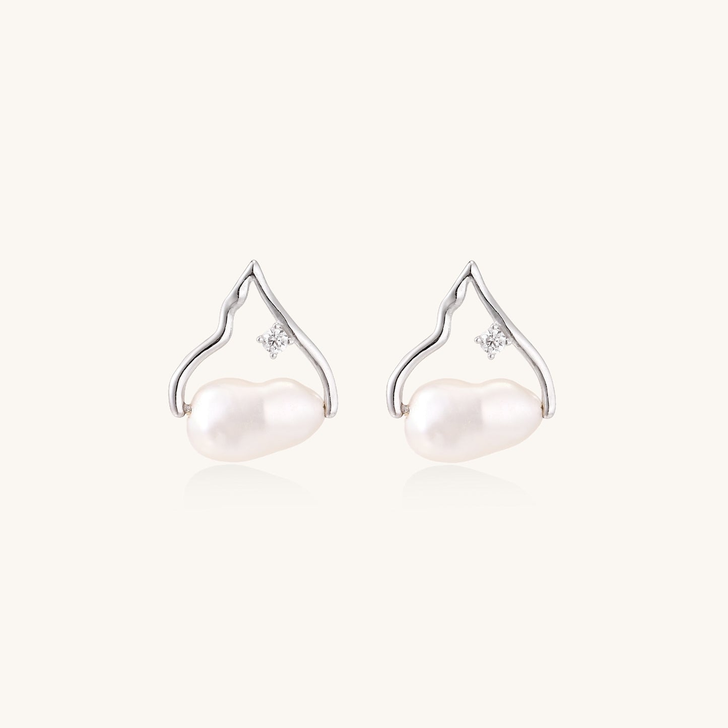 Sterling silver teardrop-shaped stud earrings with white freshwater pearls nestled in elegant flame-like frames