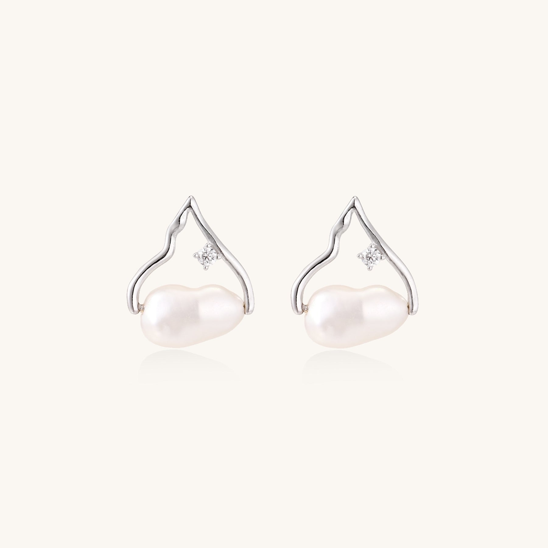 Sterling silver teardrop-shaped stud earrings with white freshwater pearls nestled in elegant flame-like frames