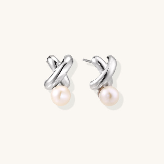 Sterling silver twisted stud earrings with round freshwater pearls on cream background, showing polished finish