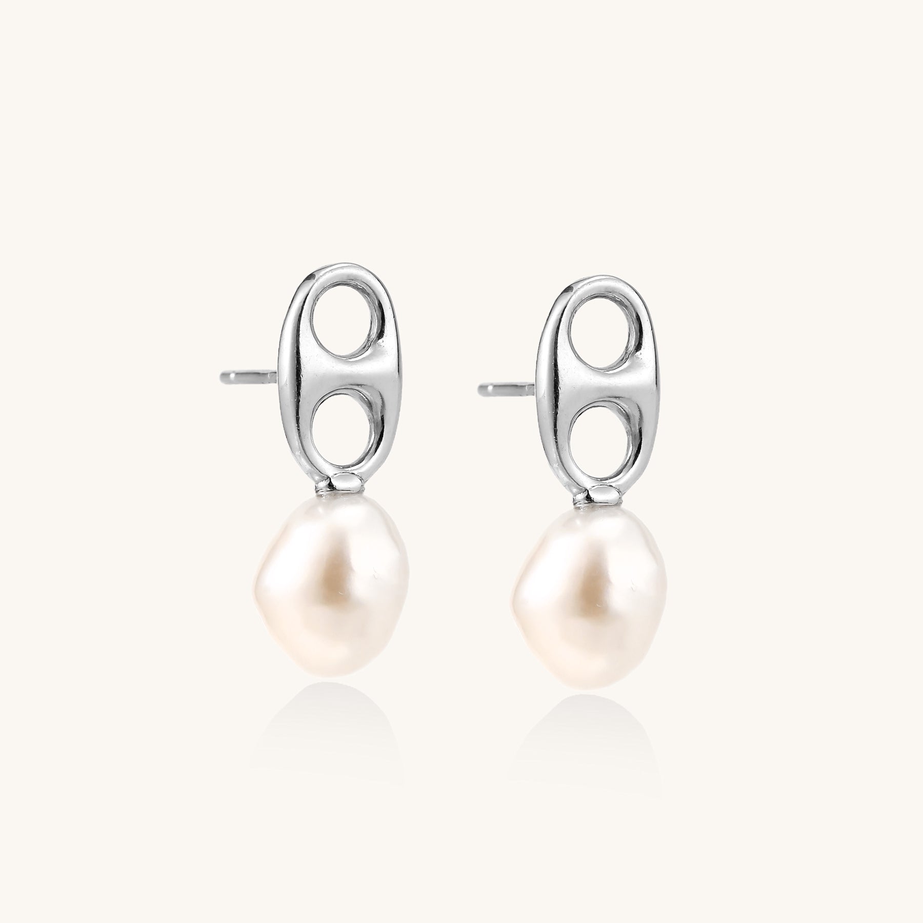 Sterling silver oval stud earrings with dual circular cutouts and suspended freshwater pearls on white background.