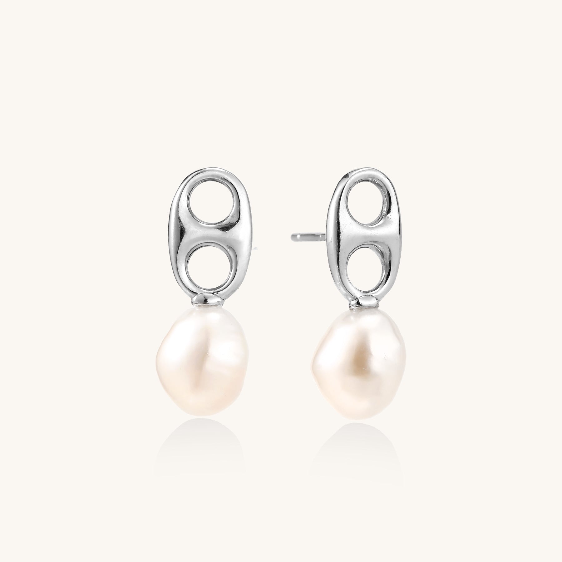 Sterling silver oval stud earrings with dual circular cutouts and suspended freshwater pearls on white background.