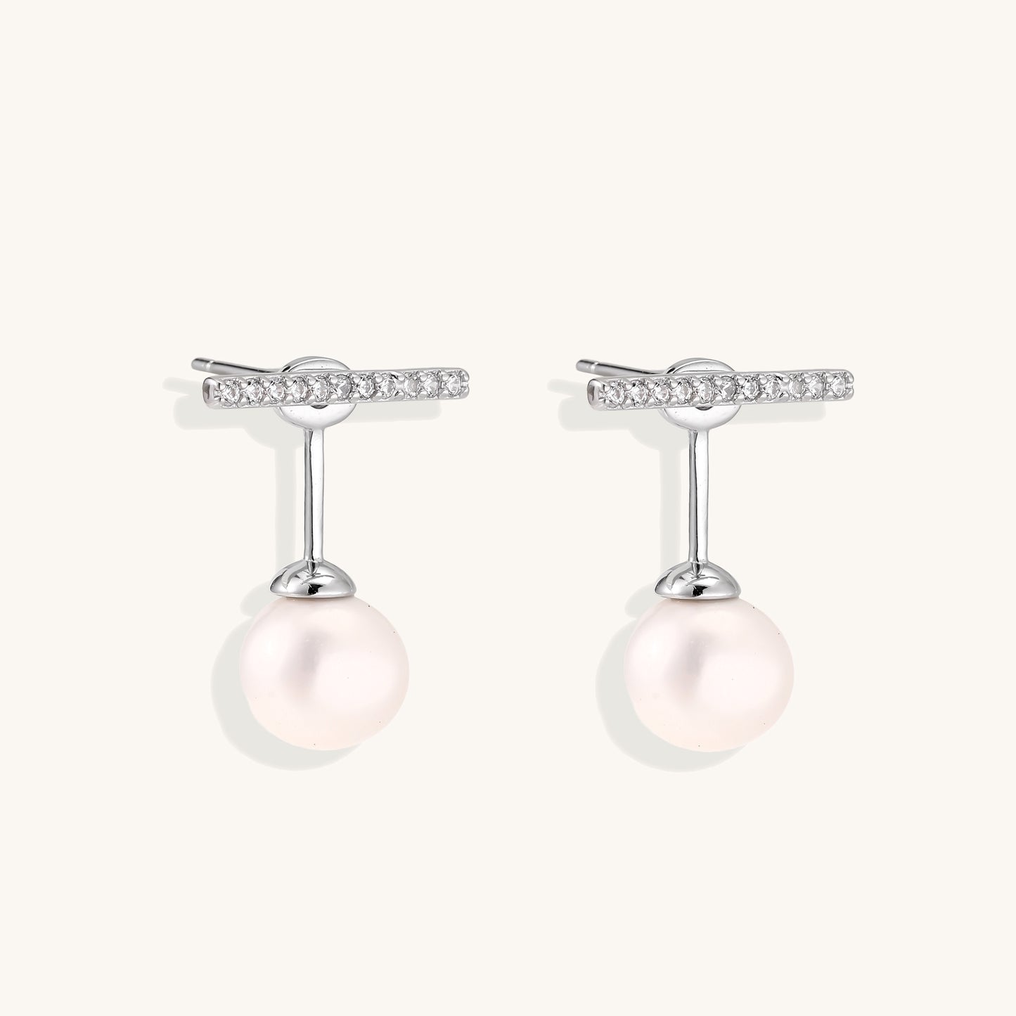 Sterling silver bar stud earrings with freshwater pearl drops on white background, minimalist jewelry design