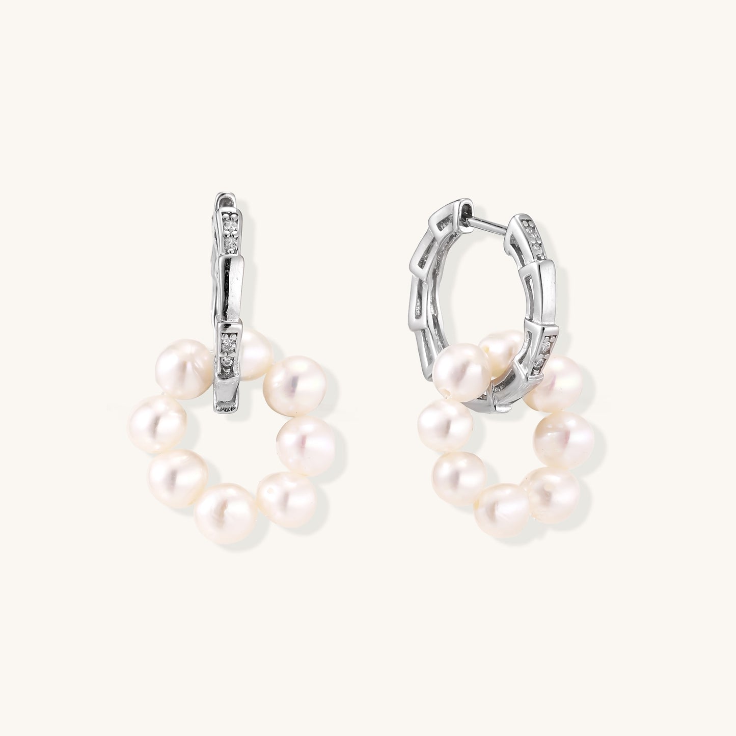 Sterling silver huggie hoop earrings with clustered white freshwater pearls and crystal accents on white background.