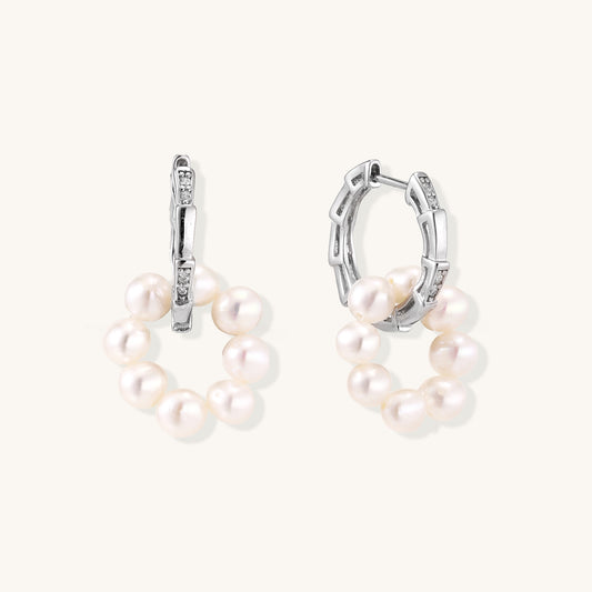 Sterling silver huggie hoop earrings with clustered white freshwater pearls and crystal accents on white background.