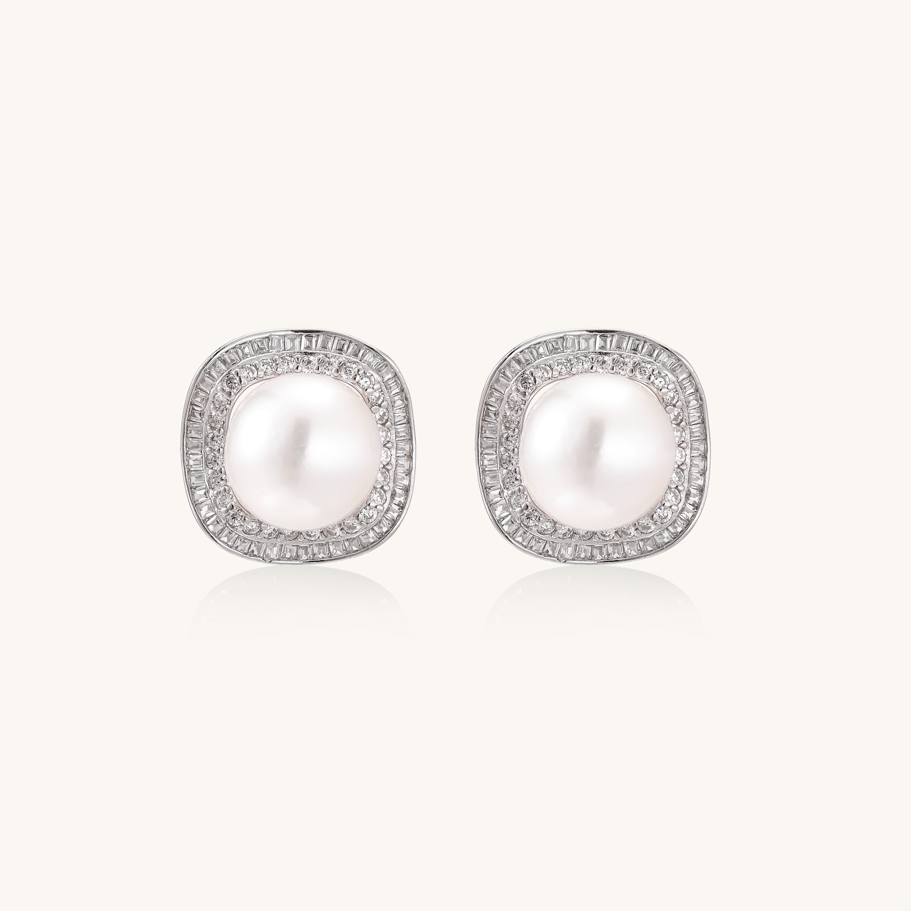 Sterling silver stud earrings with round freshwater pearls surrounded by sparkling crystal halos on white background.
