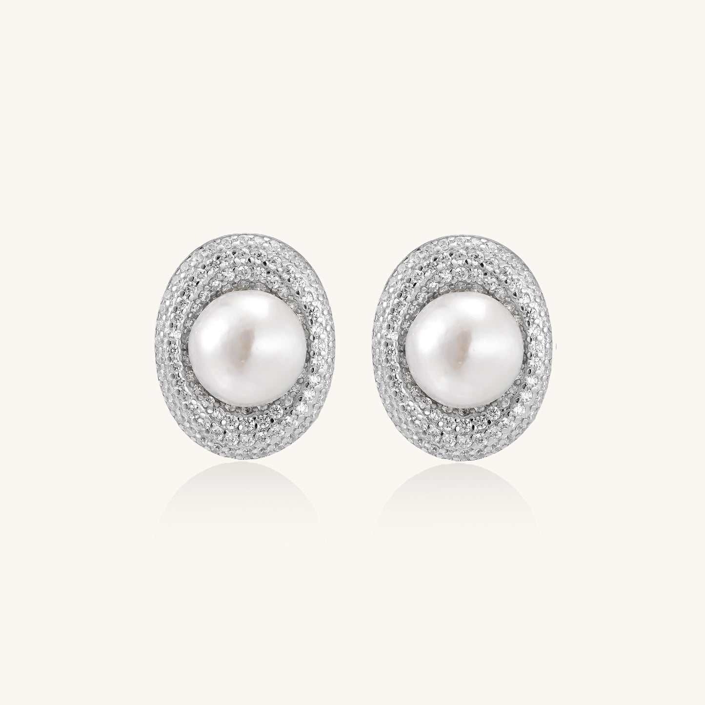Sterling silver stud earrings with freshwater pearls surrounded by sparkling pavé crystals on white background.