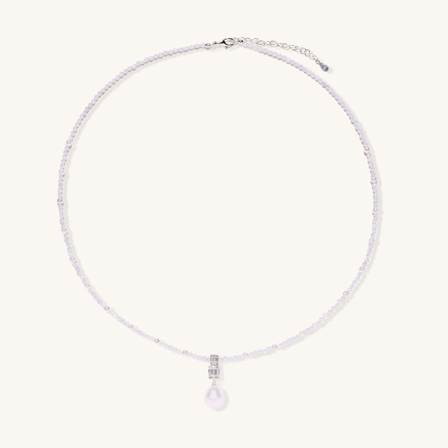 Delicate beaded necklace with lavender crystals, white pearls, and crystal pendant with pearl drop on white background.