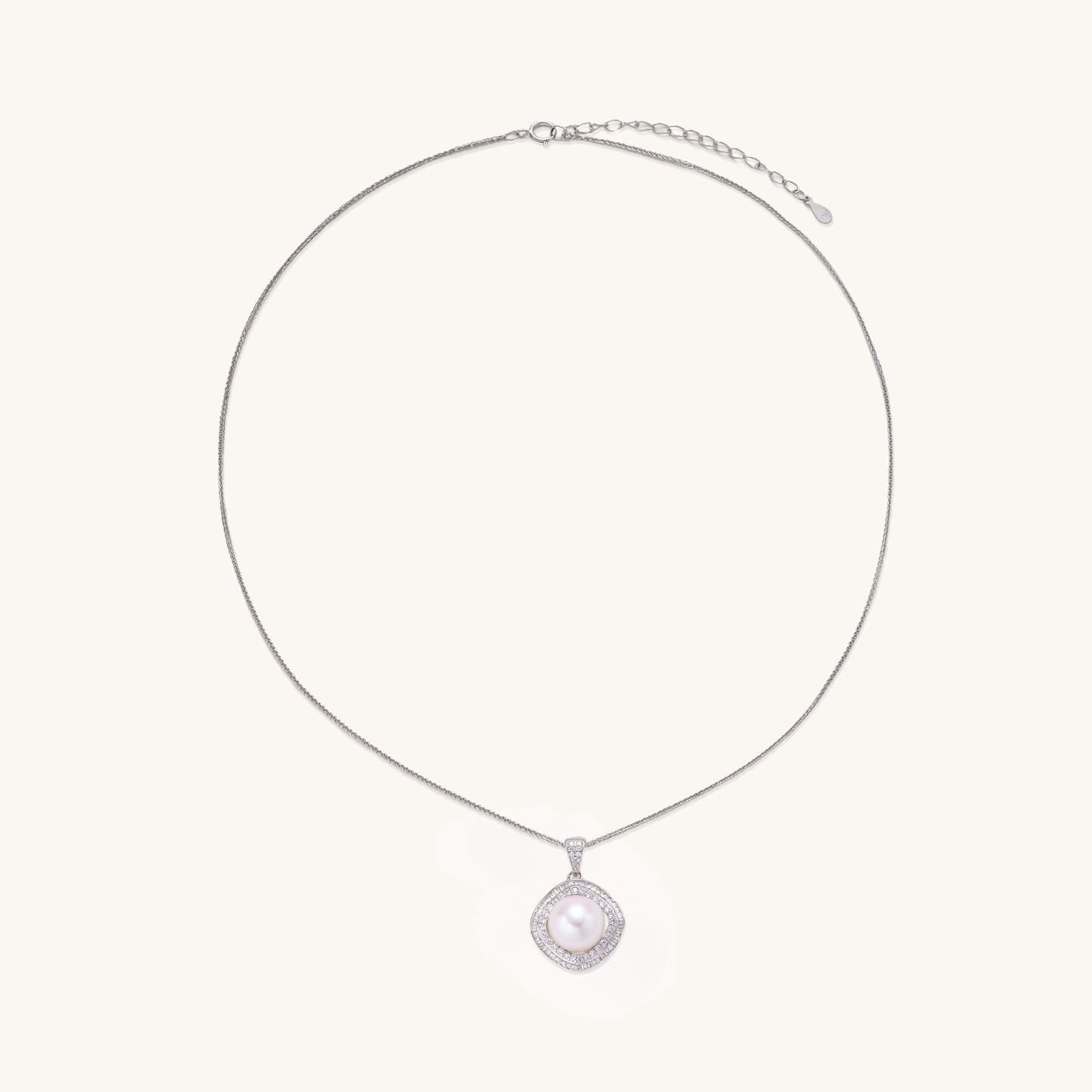 Sterling silver necklace with geometric halo setting surrounding a 10mm freshwater pearl on white background.