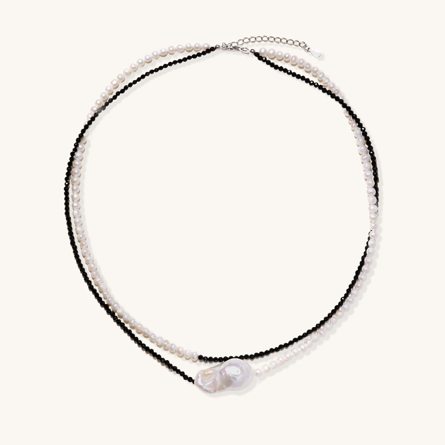 Two-strand necklace with black crystal beads and white pearls featuring a large baroque pearl centerpiece on white background.