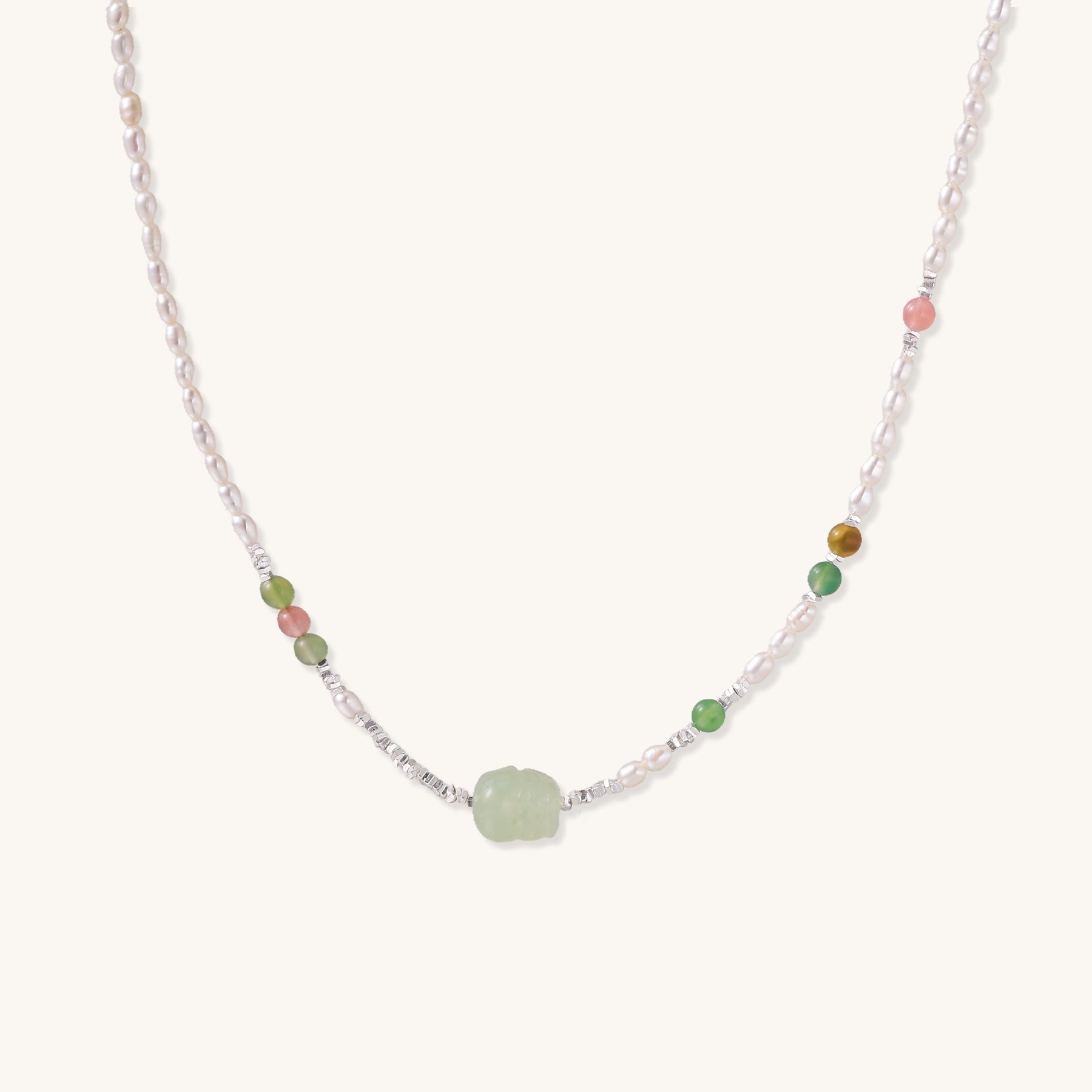 Delicate sterling silver necklace with freshwater pearls, green serpentine centerpiece, and mixed agate beads on white background.