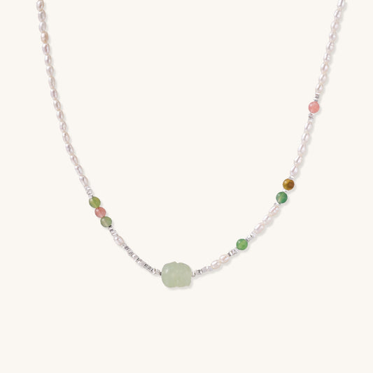 Delicate sterling silver necklace with freshwater pearls, green serpentine centerpiece, and mixed agate beads on white background.