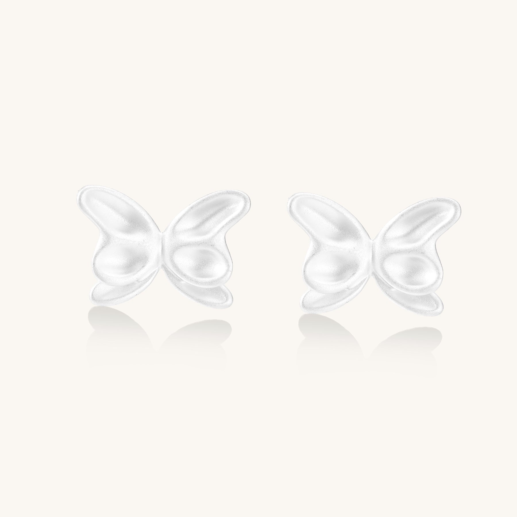 Delicate sterling silver butterfly stud earrings with intricate wing details on a neutral background.