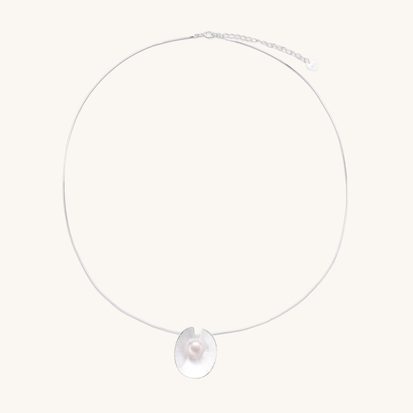 Delicate sterling silver necklace with oval iridescent pendant and central freshwater pearl on white background