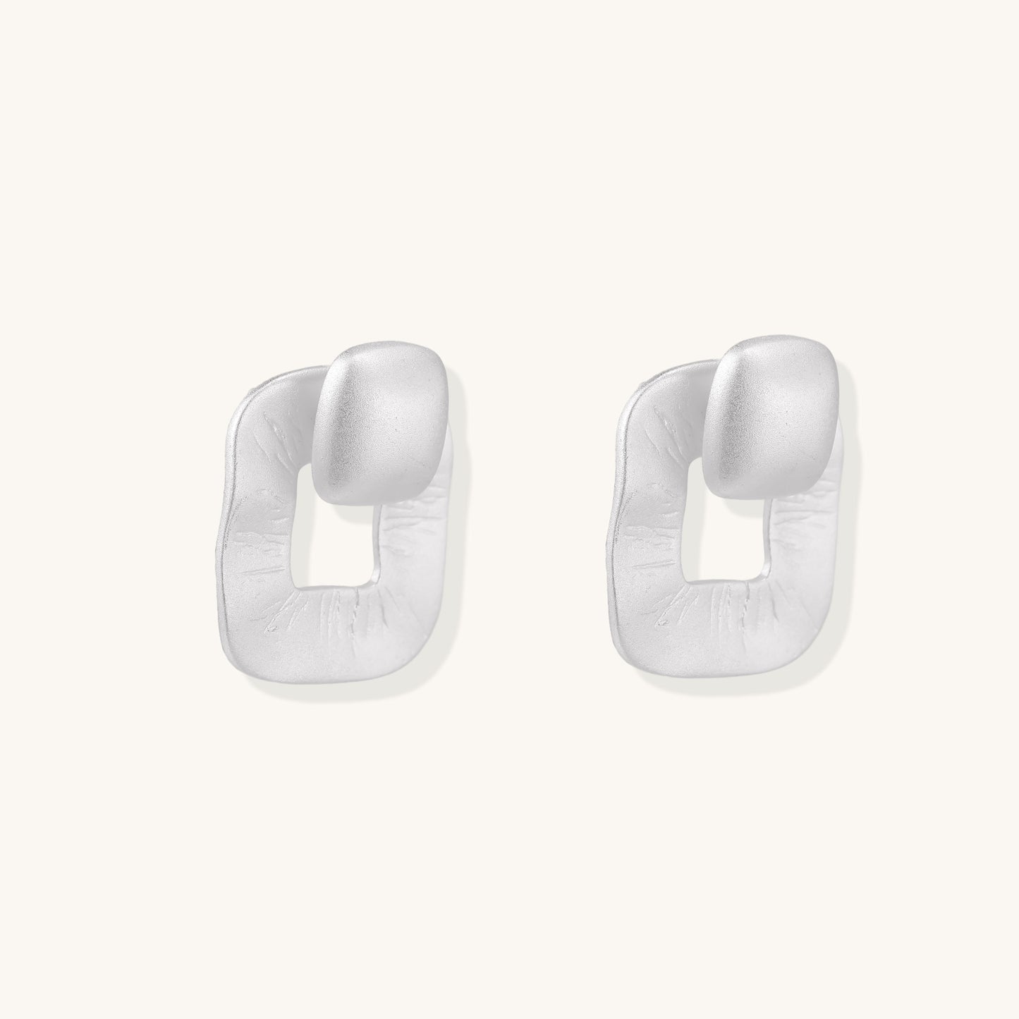 Geometric sterling silver square stud earrings with brushed texture and central square cutouts on white background.