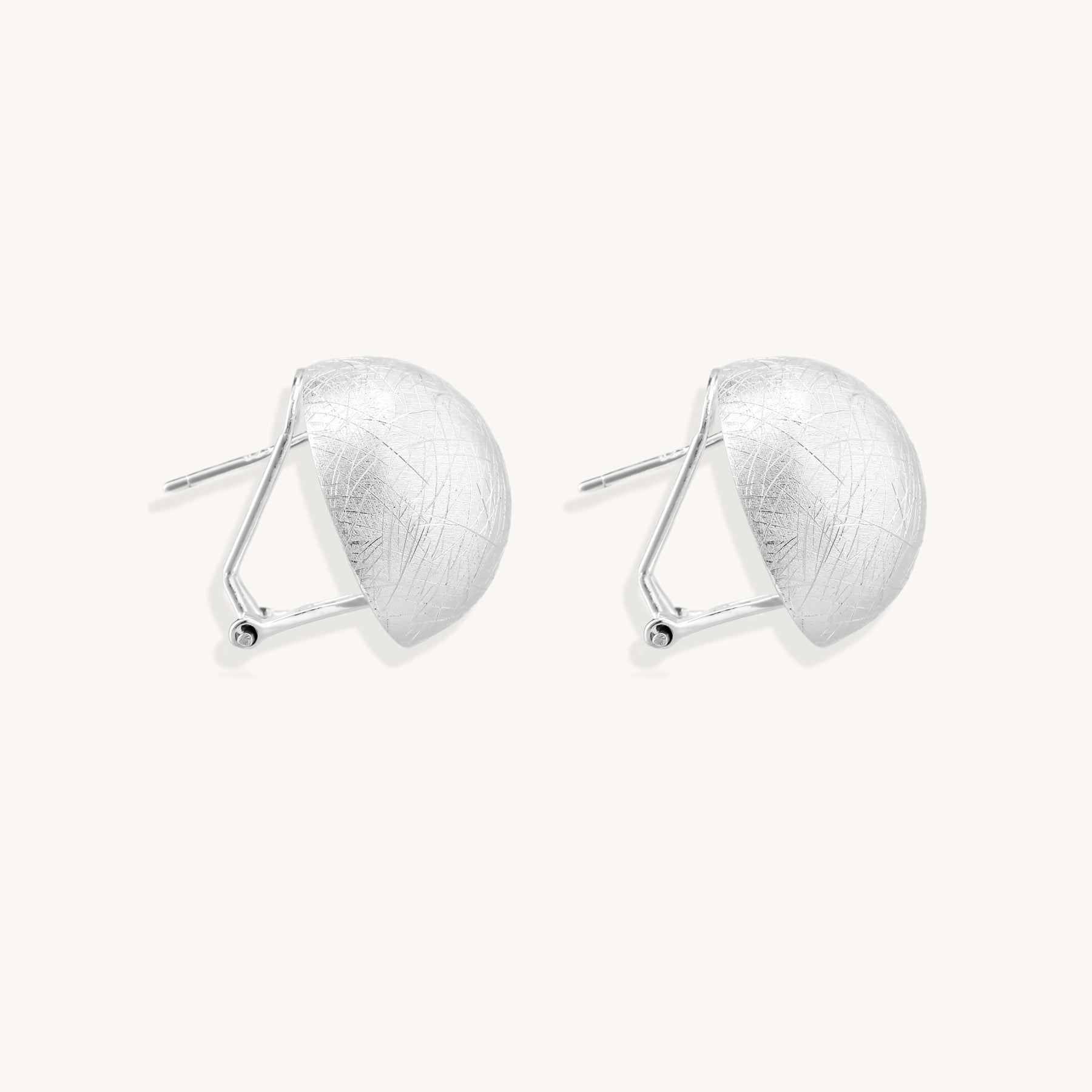 Brushed sterling silver dome-shaped stud earrings with textured surface and secure lever-back closure on white background.