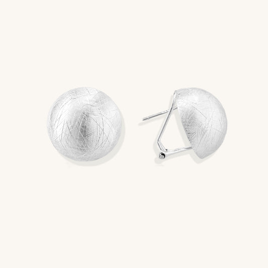 Brushed sterling silver dome-shaped stud earrings with textured surface and secure lever-back closure on white background.