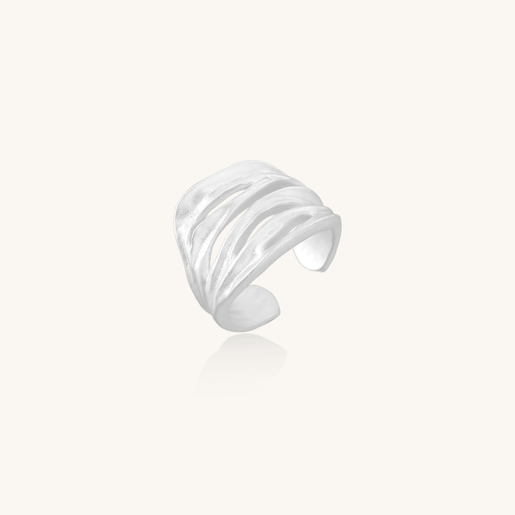 Wide sterling silver ring with flowing wave patterns and adjustable cuff design on white background.