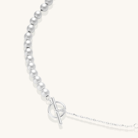 Sterling silver necklace with graduated pearl beads and delicate chain sections featuring a toggle clasp closure.