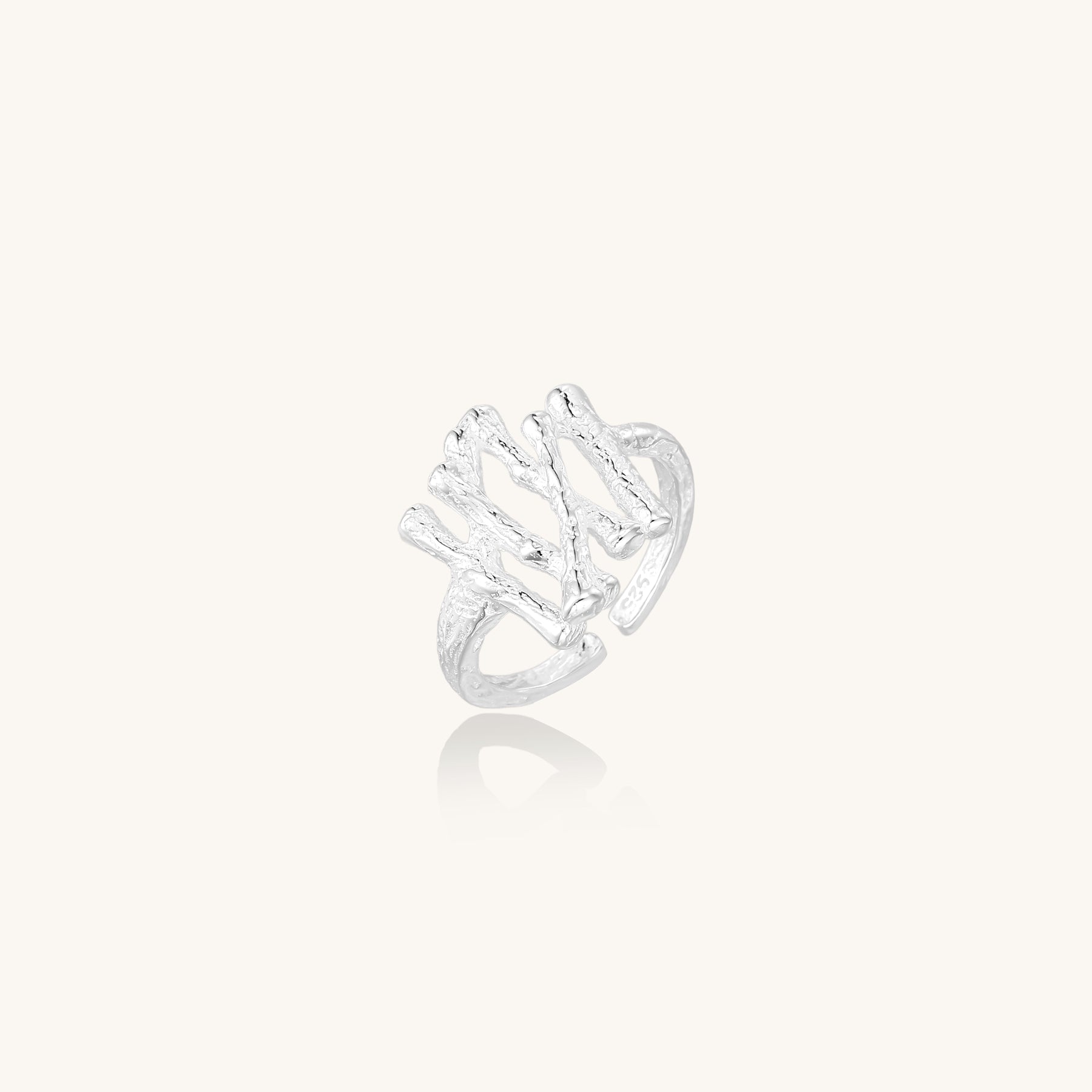 Chunky sterling silver ring with organic sculptural design and flowing abstract forms on white background
