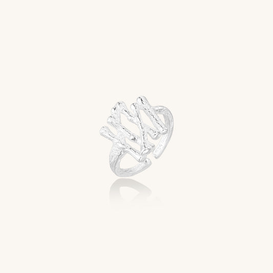 Chunky sterling silver ring with organic sculptural design and flowing abstract forms on white background