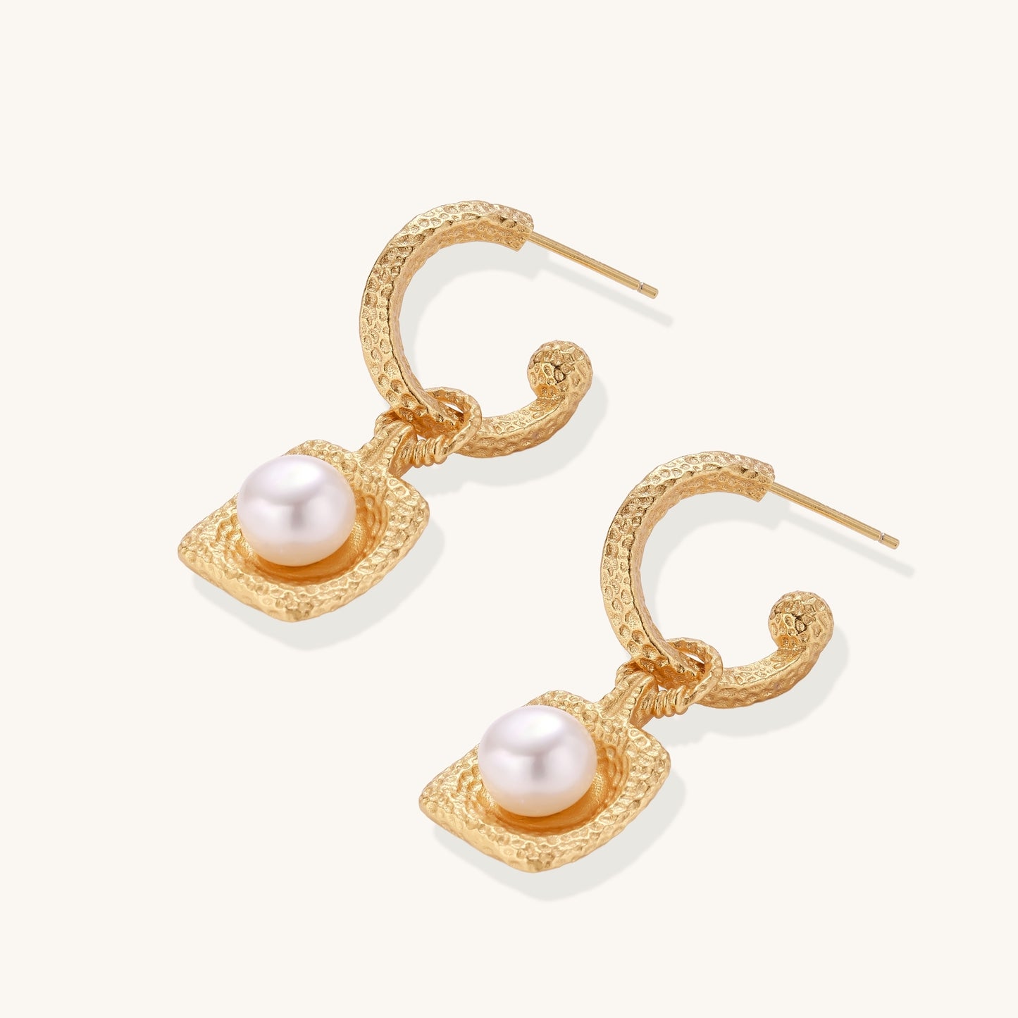 Gold-plated textured hoop earrings with square pendants containing freshwater pearls on white background