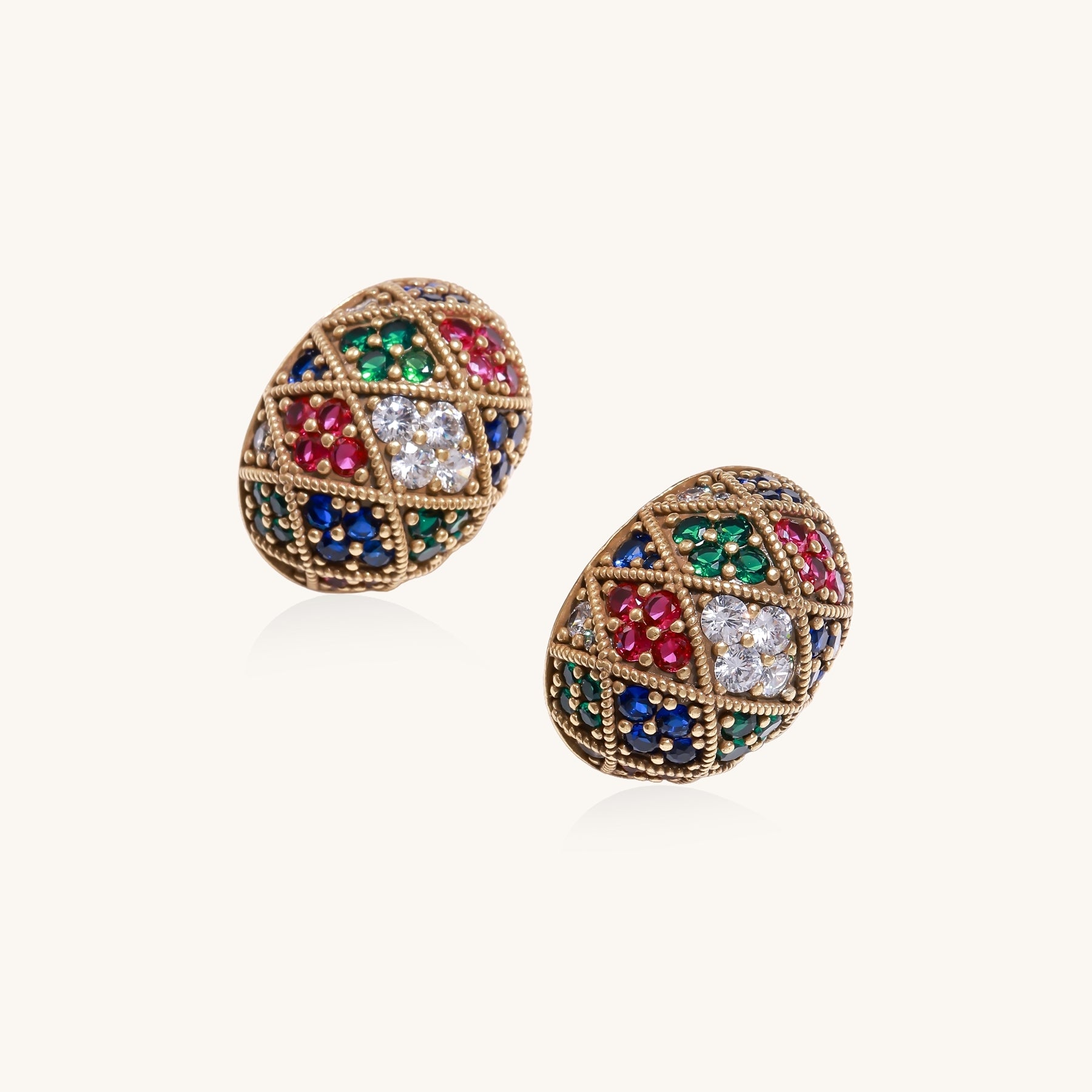 Oval gold-plated stud earrings with multicolor zirconia stones in geometric diamond pattern on white background.