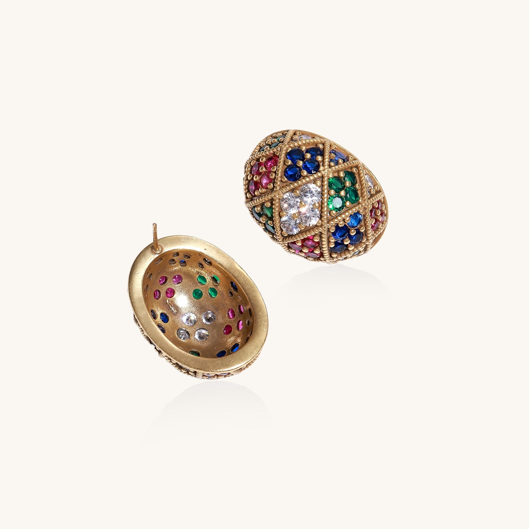 Oval gold-plated stud earrings with multicolor zirconia stones in geometric diamond pattern on white background.