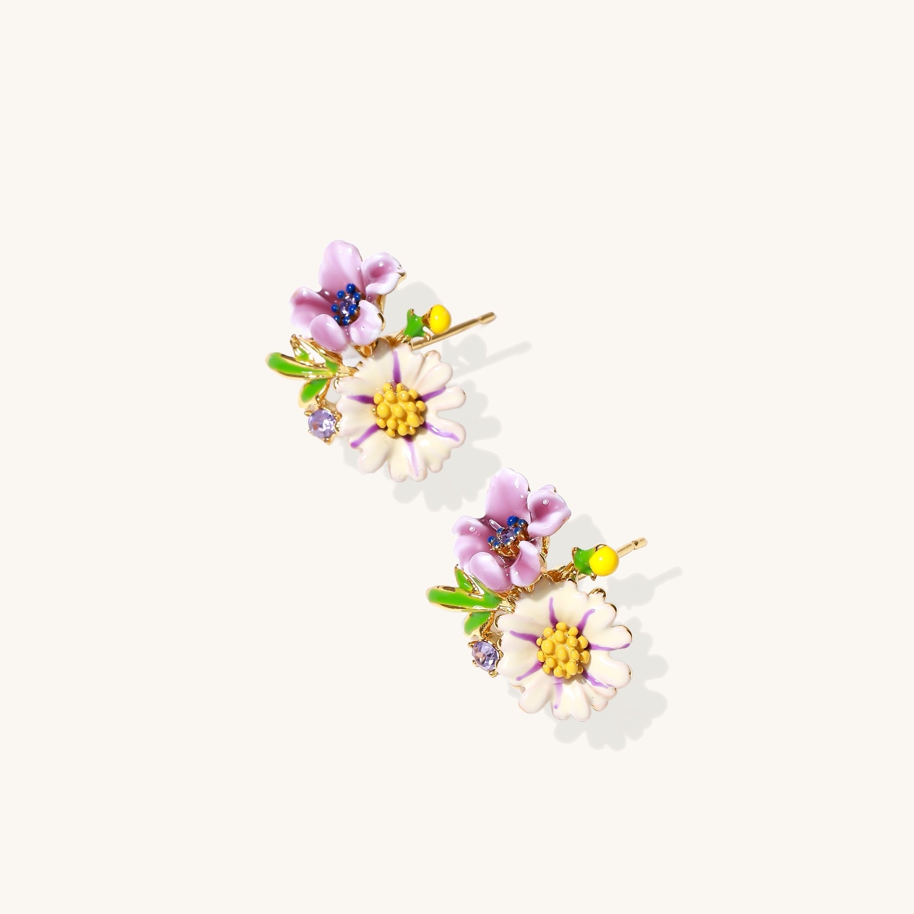 Delicate gold-plated stud earrings featuring white daisy and purple flowers with green leaves and crystal accents