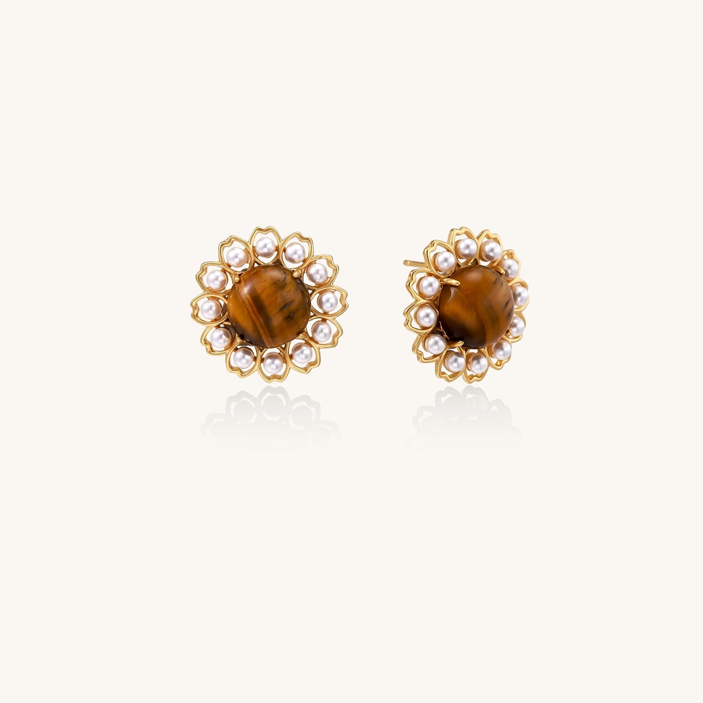 Gold-plated stud earrings with round tiger's eye stones surrounded by small pearls in a floral pattern.