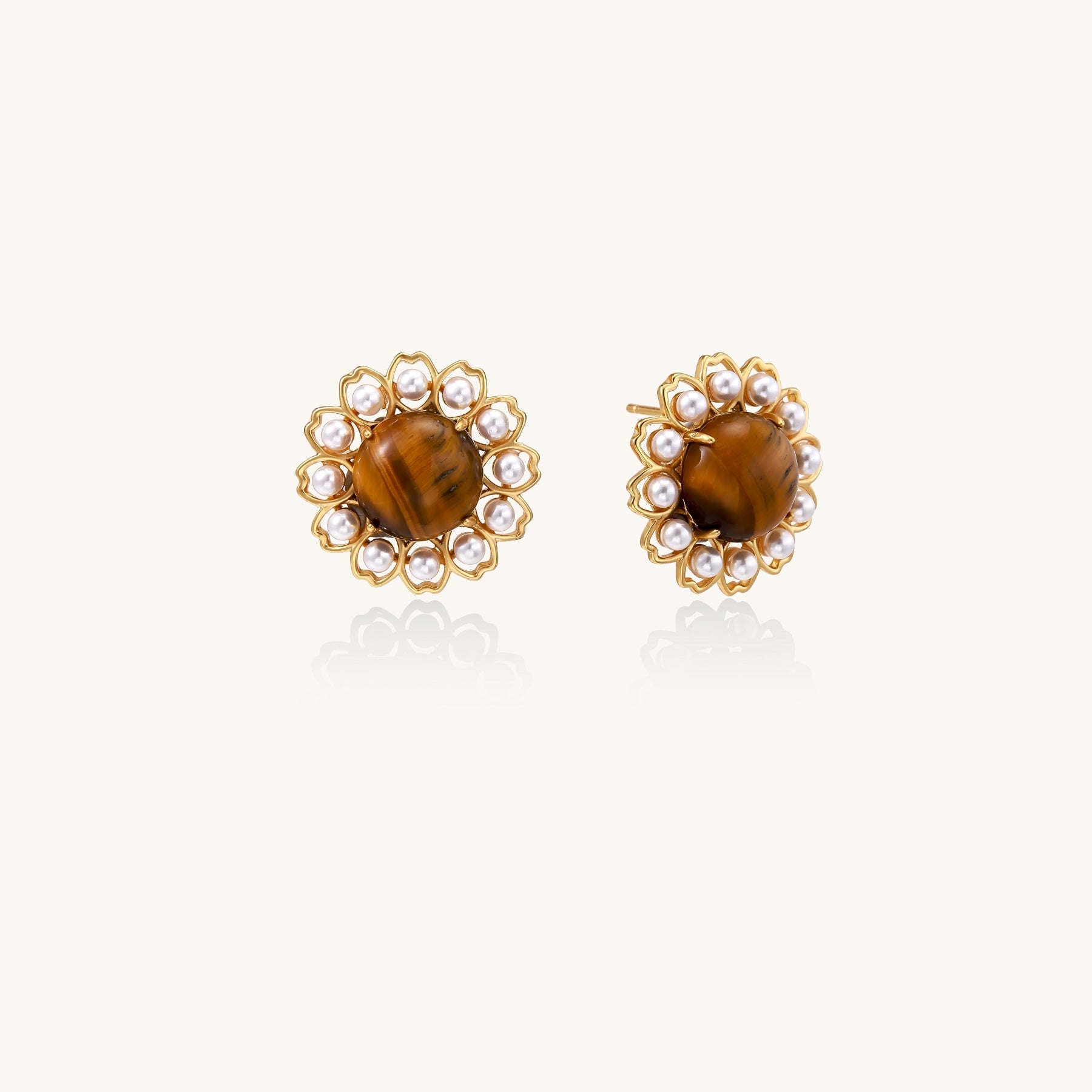 Gold-plated stud earrings with round tiger's eye stones surrounded by small pearls in a floral pattern.