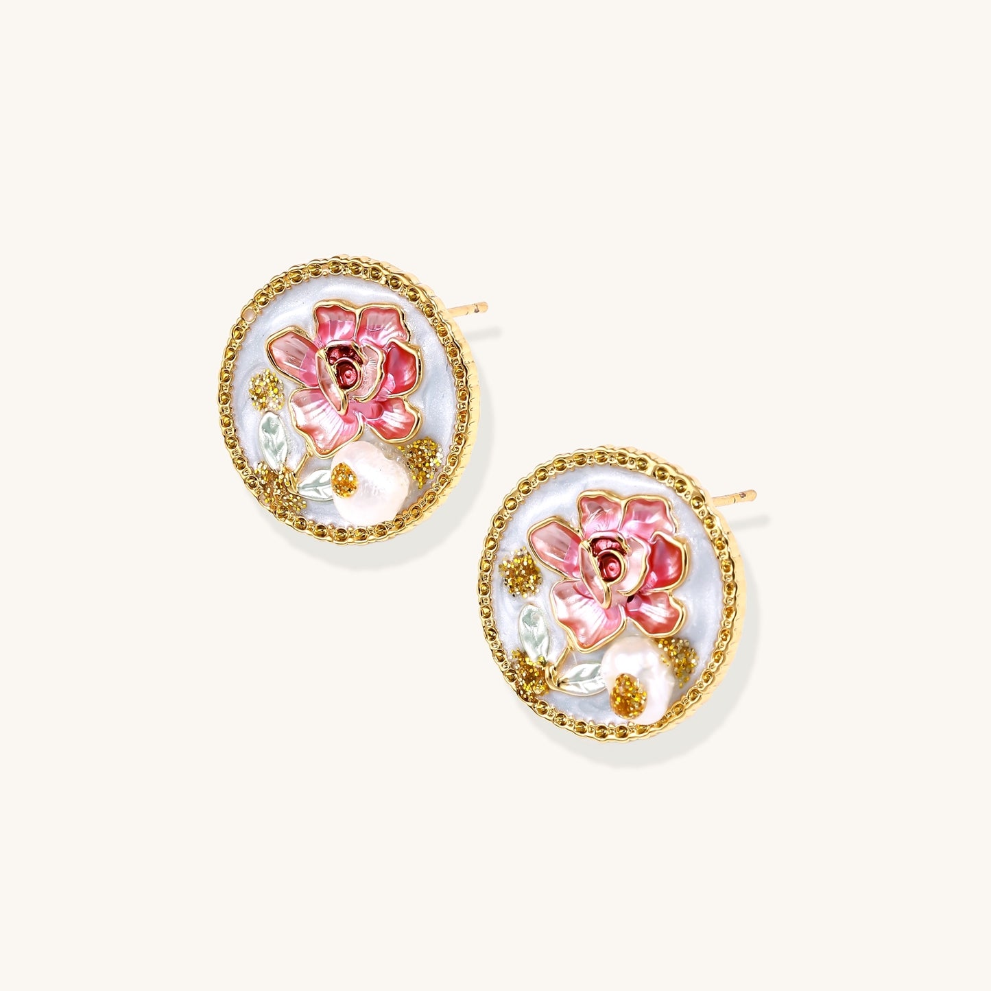 Round gold-plated stud earrings featuring pink enamel roses with freshwater pearl accents on white background.