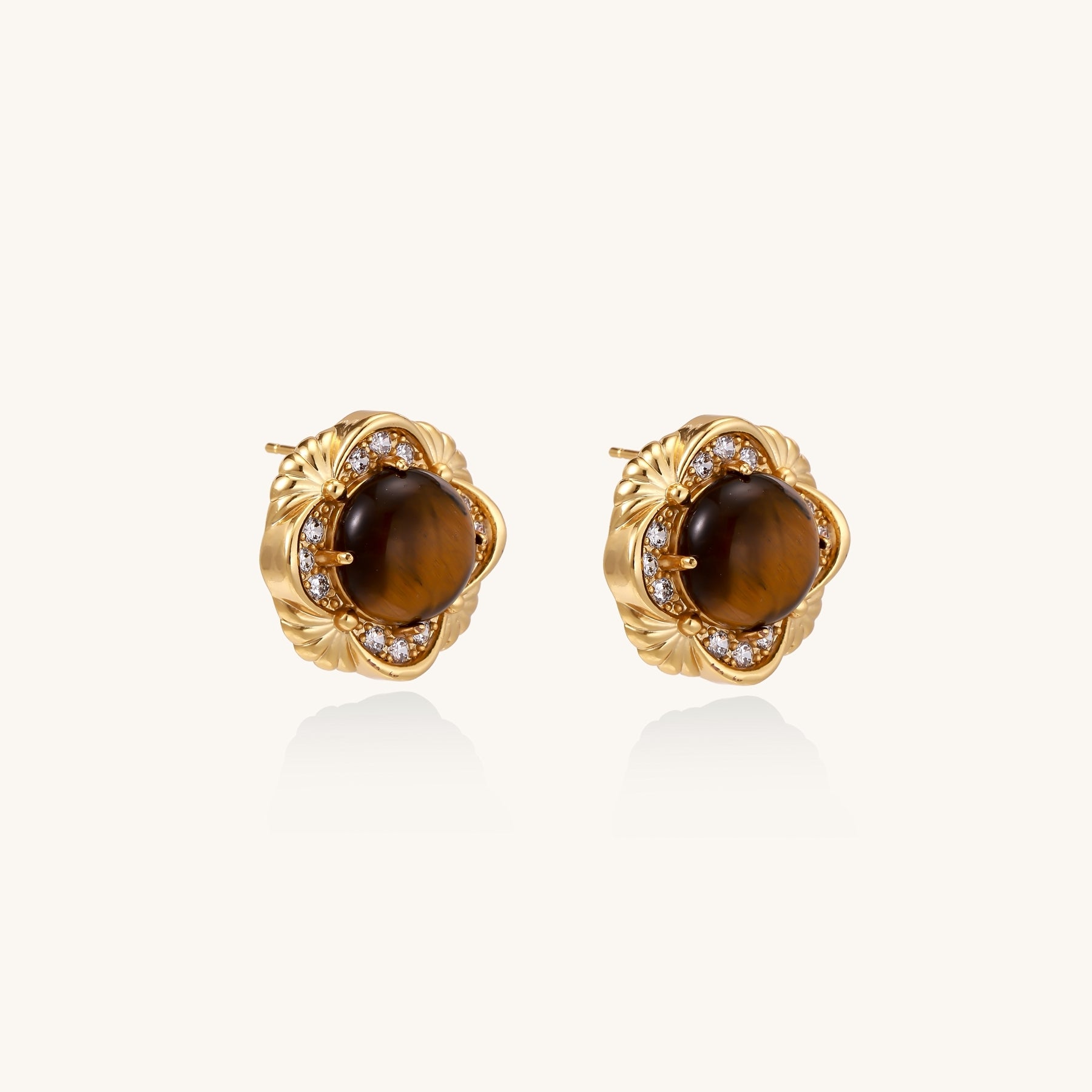 Ornate gold-plated brass stud earrings featuring round tiger's eye stones surrounded by sparkling zirconia in floral design
